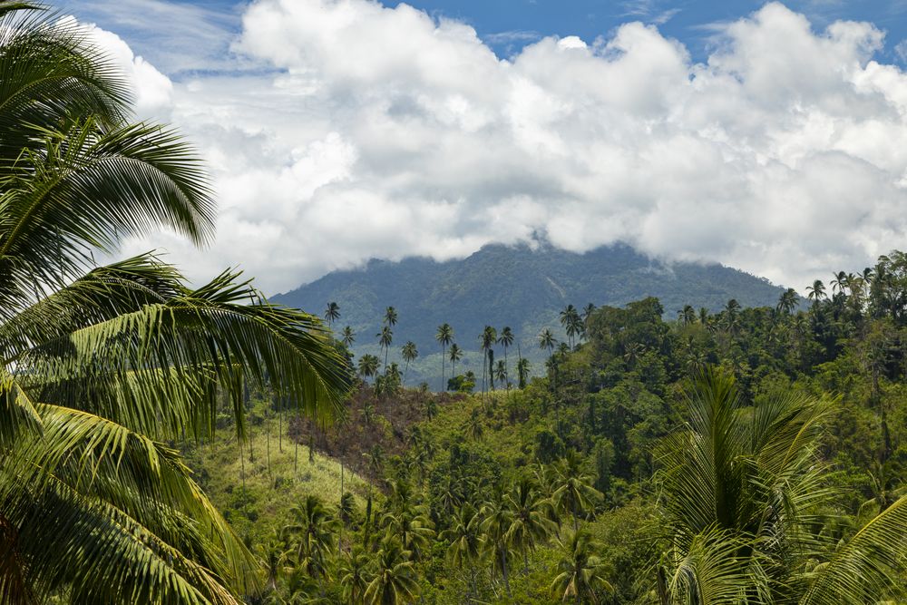 Klabat volcano in the distance behind clouds, North Minahasa, Sulawesi, Indonesia