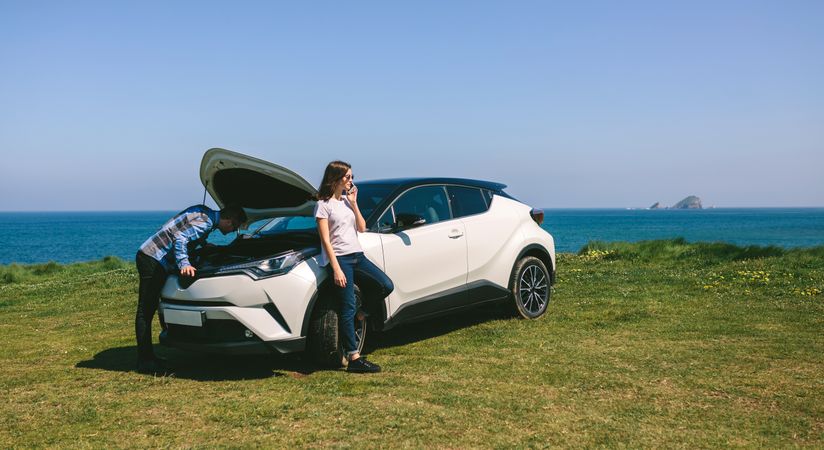 Young couple with the broken down car