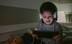 Girl with headphones looking at the tablet