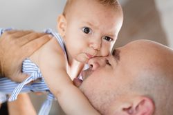 Father kissing baby on cheek