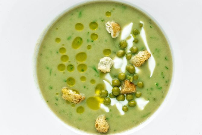 Green vegetable cream soup with peas and crackers