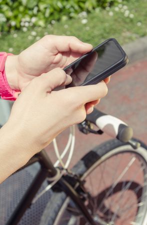 Sportive woman with fixie bike looking smartphone