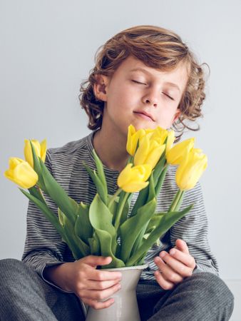 Cute boy with bouquet of tulips in vase