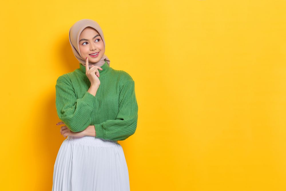 Smiling woman in headscarf looking to the side and thinking