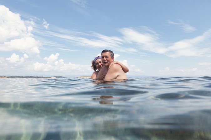 Mature couple swimming together in fresh water
