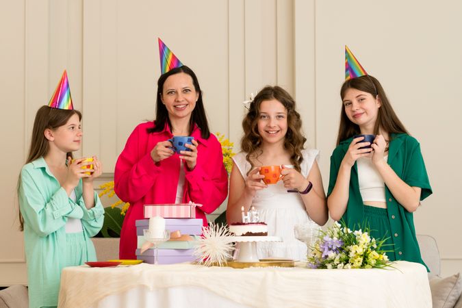 Family wearing festive hats celebrates a birthday together