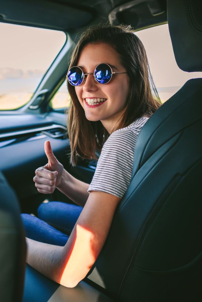 Woman doing thumbs up in the car