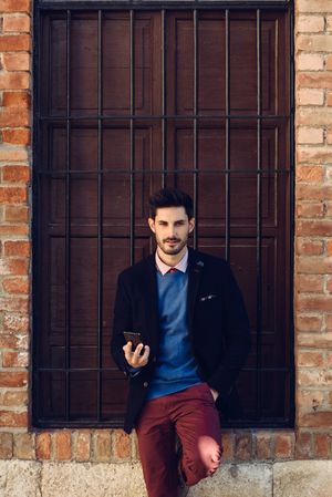 Man in suit standing outside with smartphone