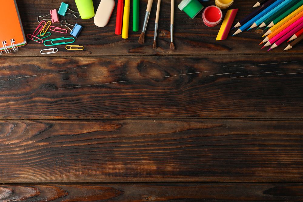 Flat lay composition with school supplies on wooden background, space for text