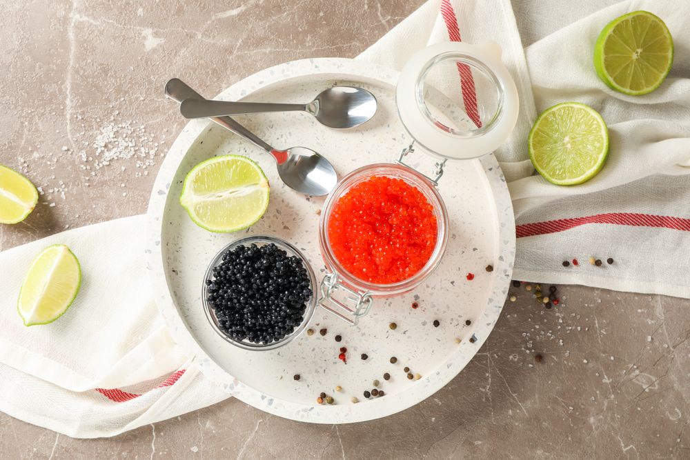 Appetizing composition with caviar and citrus on grey table, top view