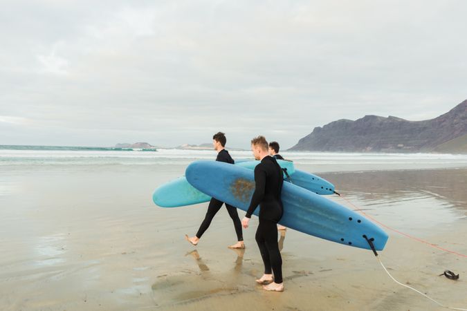 People with surfboard walking near sea