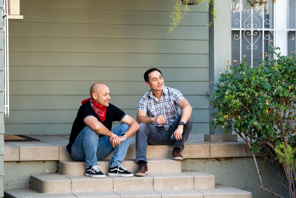 Two men enjoying an afternoon sitting on their front porch