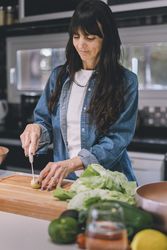 Housewife chopping baby potatoes. Vertical shot.