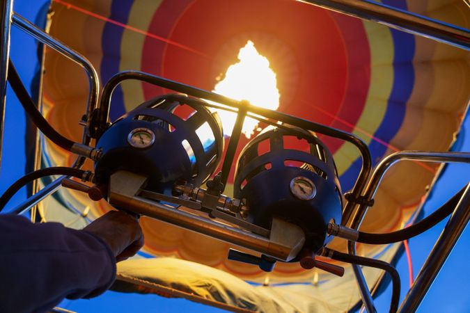 Close up of hand switching on flame heating hot air balloon before flight