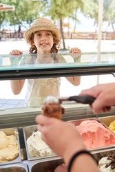 Cheerful boy near ice cream parlor