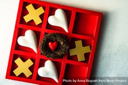 St. Valentine day card concept with heart in nest in center of tic-tac-toe game 0LdrAg