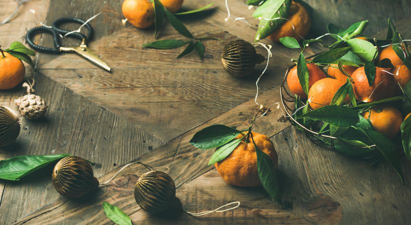 Freshly picked tangerines with leaves on wooden table, with Christmas decorations