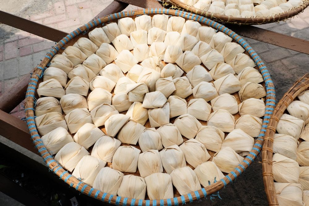 Wajit Cililin cooking in circular dish, sticky rice steamed in corn leaf, traditional Indonesian street food