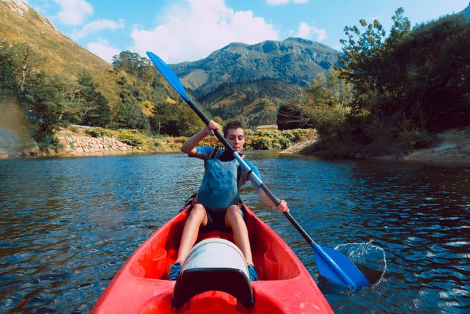 Young female kayaking on nature background