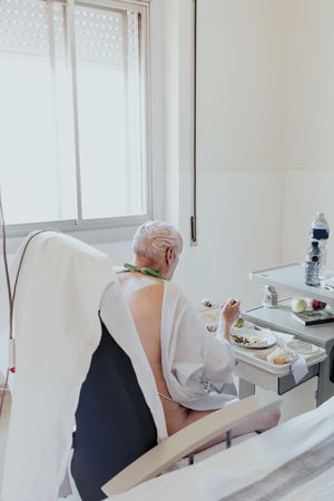 Older man admitted to a hospital room.