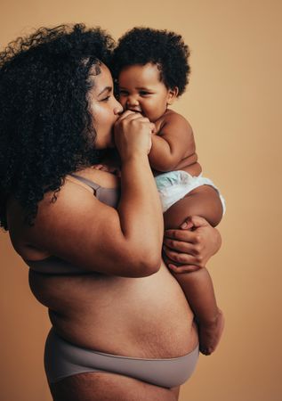 Mother with pregnancy stretch marks holding her child