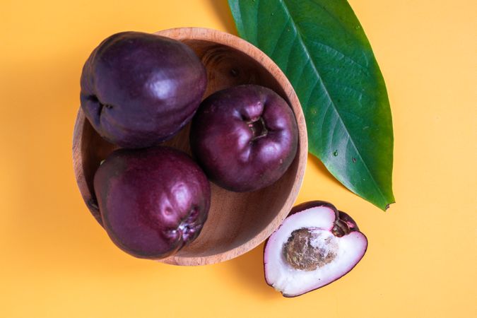 Four Syzygium malaccense or known as jambu jamaika fruits are on a yellow background