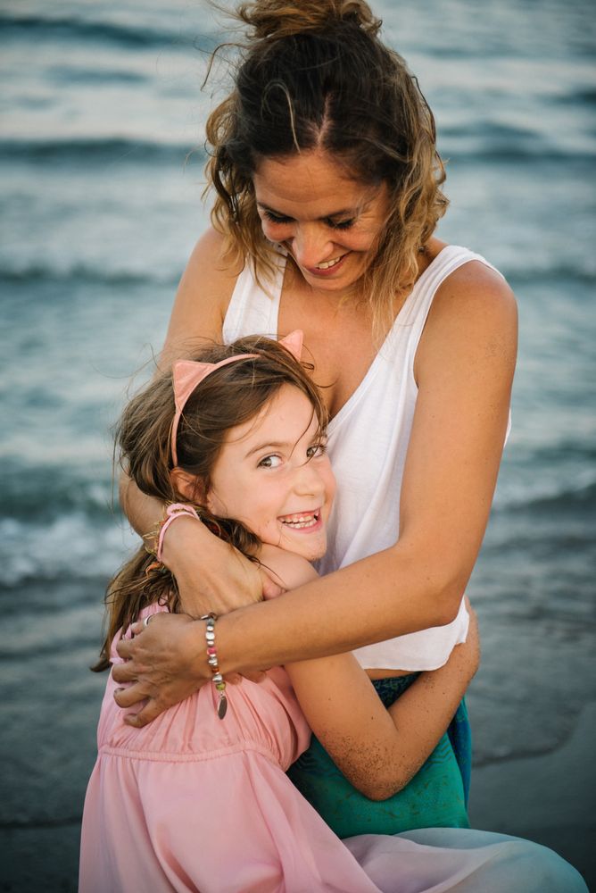 Beautiful mother and daughter embracing on beach