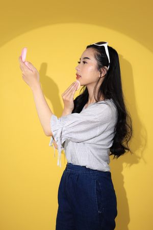 Young Woman Touch Her Make Up using Sponge Puff