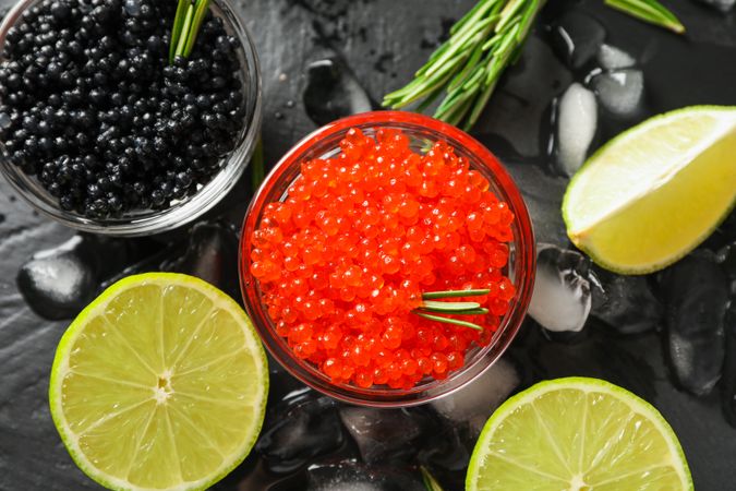 Fresh composition with caviar and citrus on dark table, close up