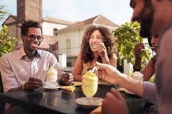 Group of friends laughing at an outdoor cafe in Italy