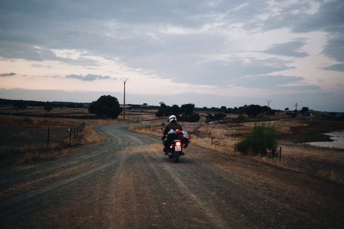 Man riding motorcycle down rural road