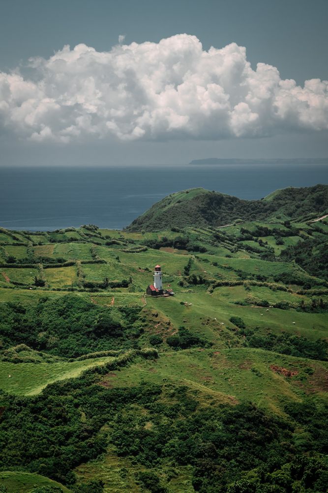 Lighthouse tower at daytime amid green field