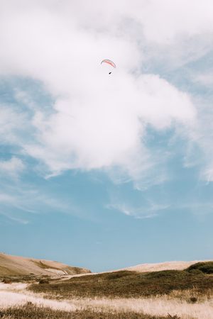 Faceless people paragliding in blue sky