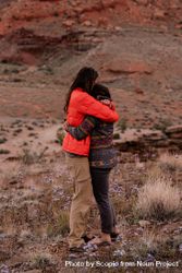 Two people hugging on soil field bYknG5