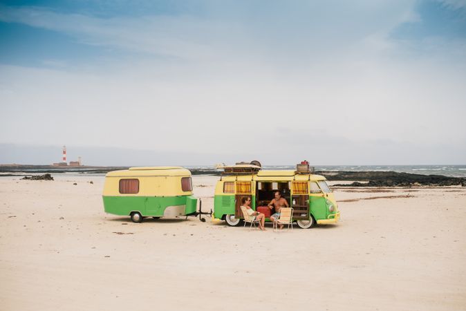 Friends in minibus with trailer on beach