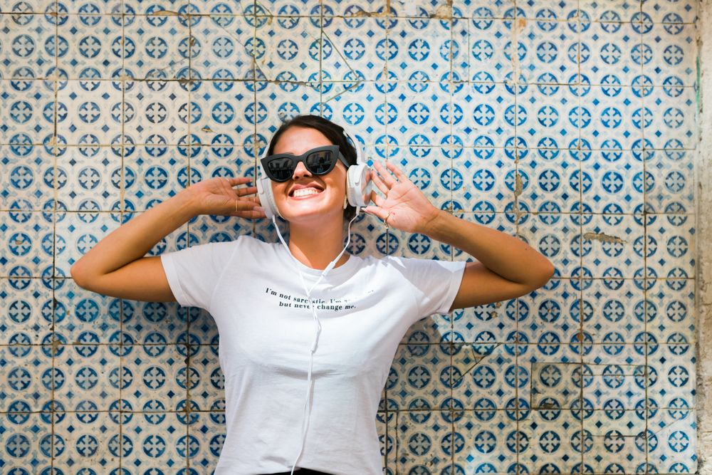 Cheerful casual woman in sunglasses standing on city street