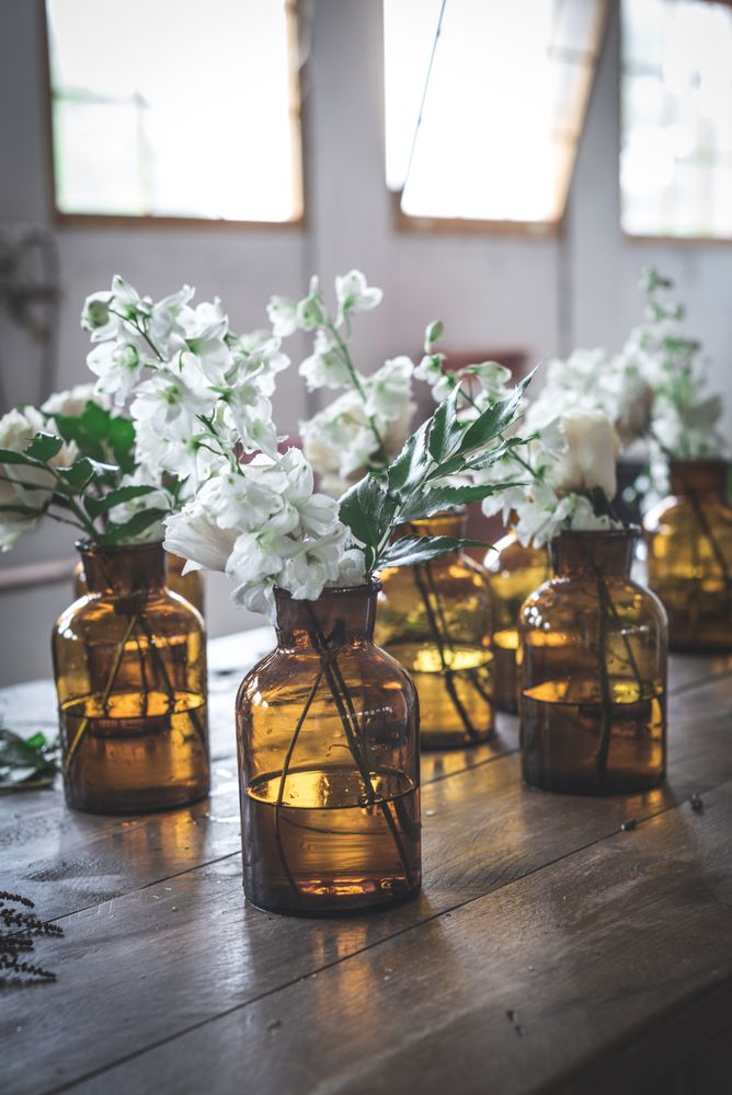 flower twigs in vintage vases on table