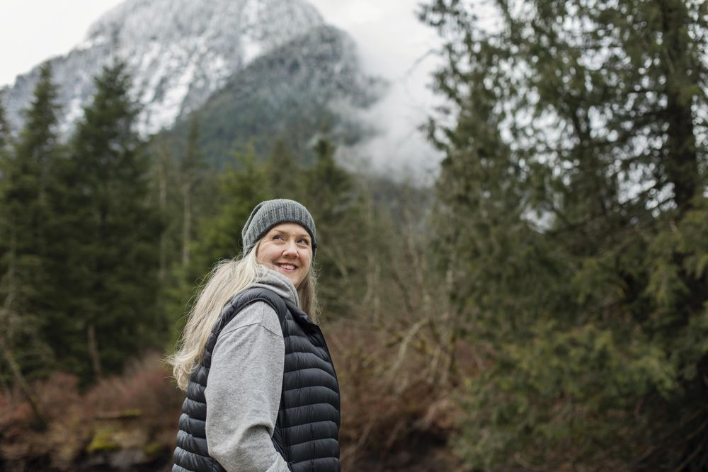 Happy woman in the woods looking up over her shoulder