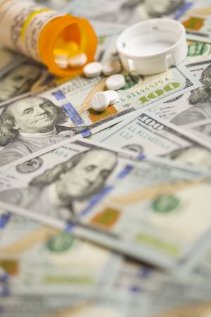 Medicine Pills Scattered on Newly Designed One Hundred Dollar Bills