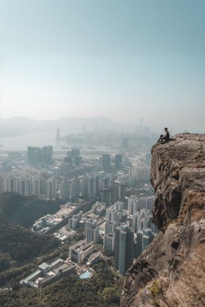 Side view of a person sitting on Suicide cliff in Hong Kong