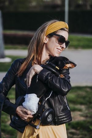 Woman showing dog with wheelchair on street