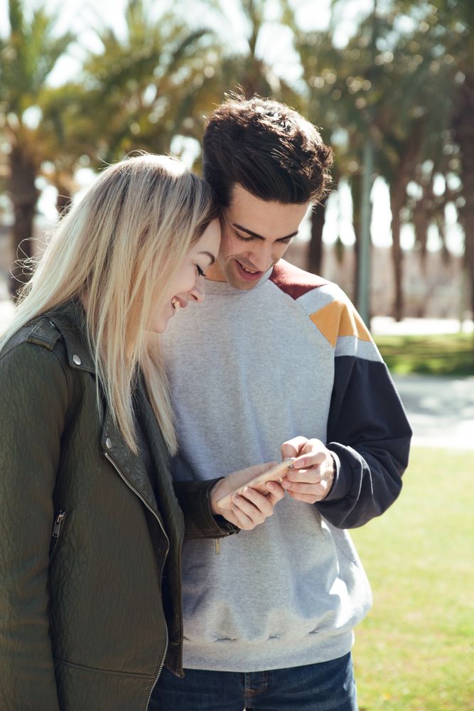 Couple using phone outdoors