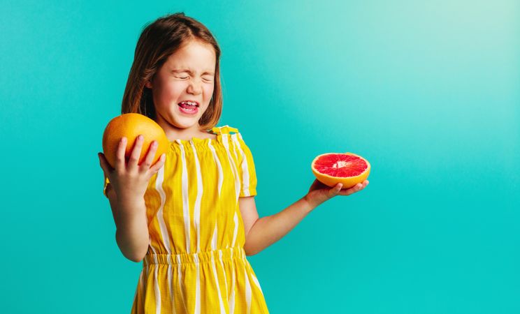 Girl with grapefruit on a blue background