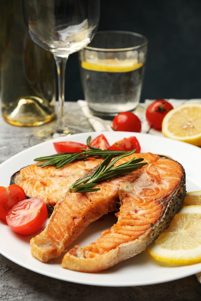 Composition with tasty grilled salmon on gray background, close up
