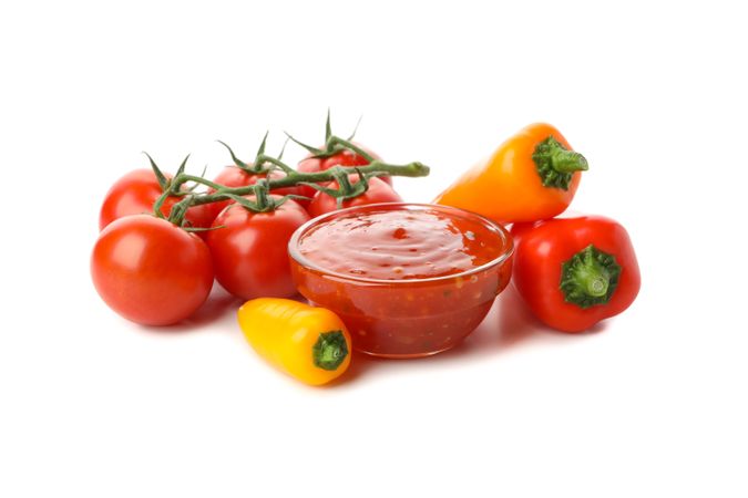 Branch of tomatoes, pepper and sauce isolated on plain background