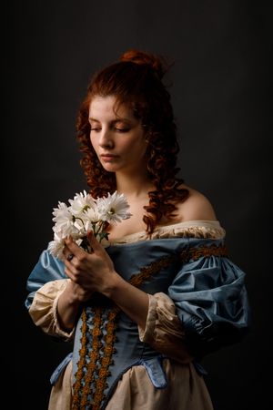 Baroque woman with closed eyes holding flowers