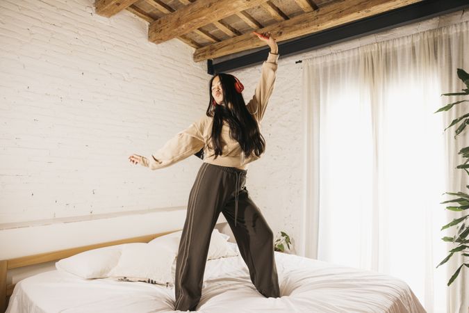 Young woman dancing on a bed