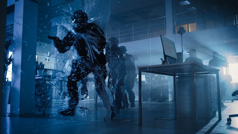 Masked Squad of Armed SWAT Police Officers Storm a Dark Seized Office Building with Desks and Computers.