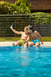 Boys on poolside taking selfie