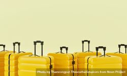 Yellow hard shell roller suitcases arranged on light yellow background 0L7oeb